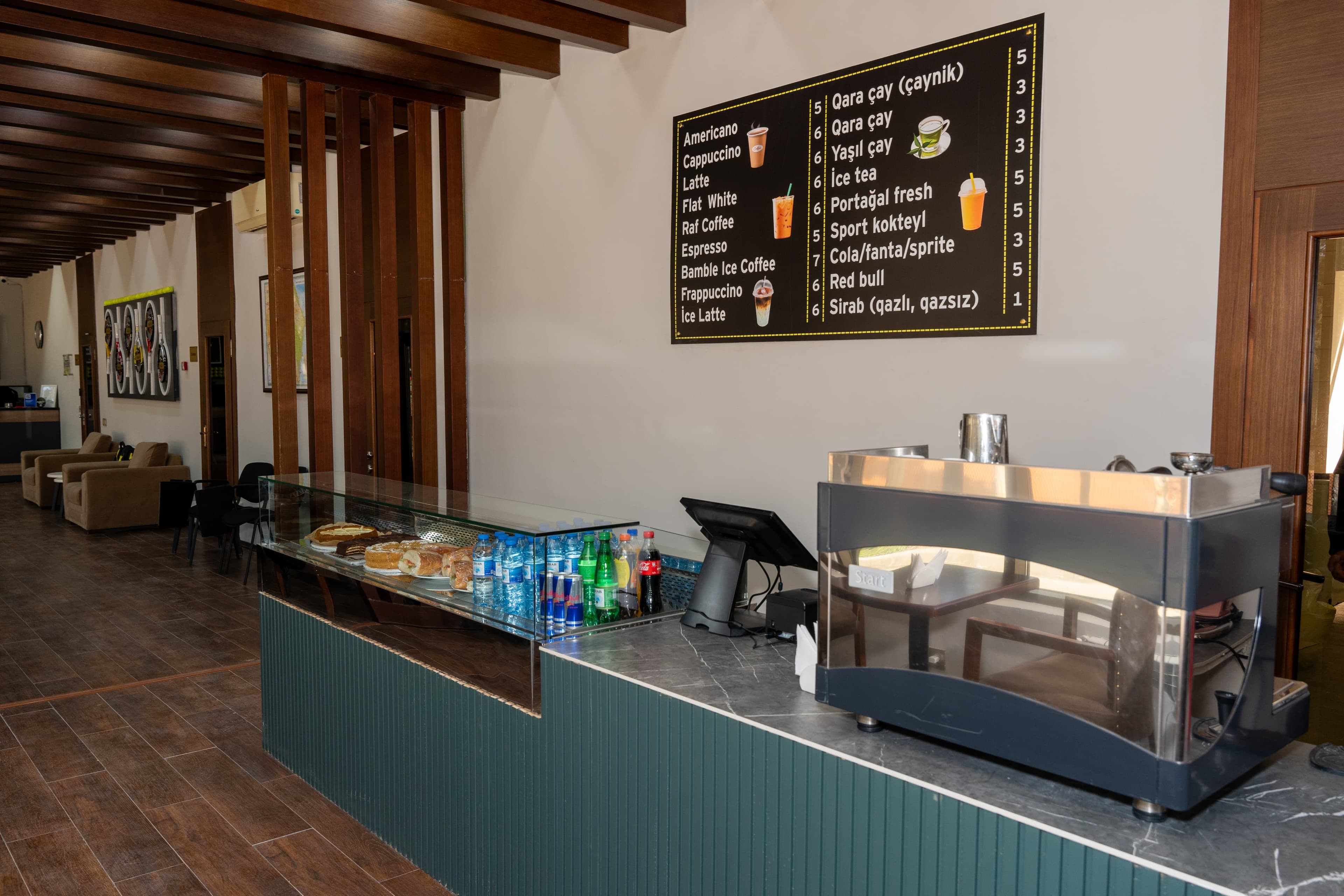 Klub kafesinin espresso maşını, şirniyyat və içki menyusu ilə piştaxtası